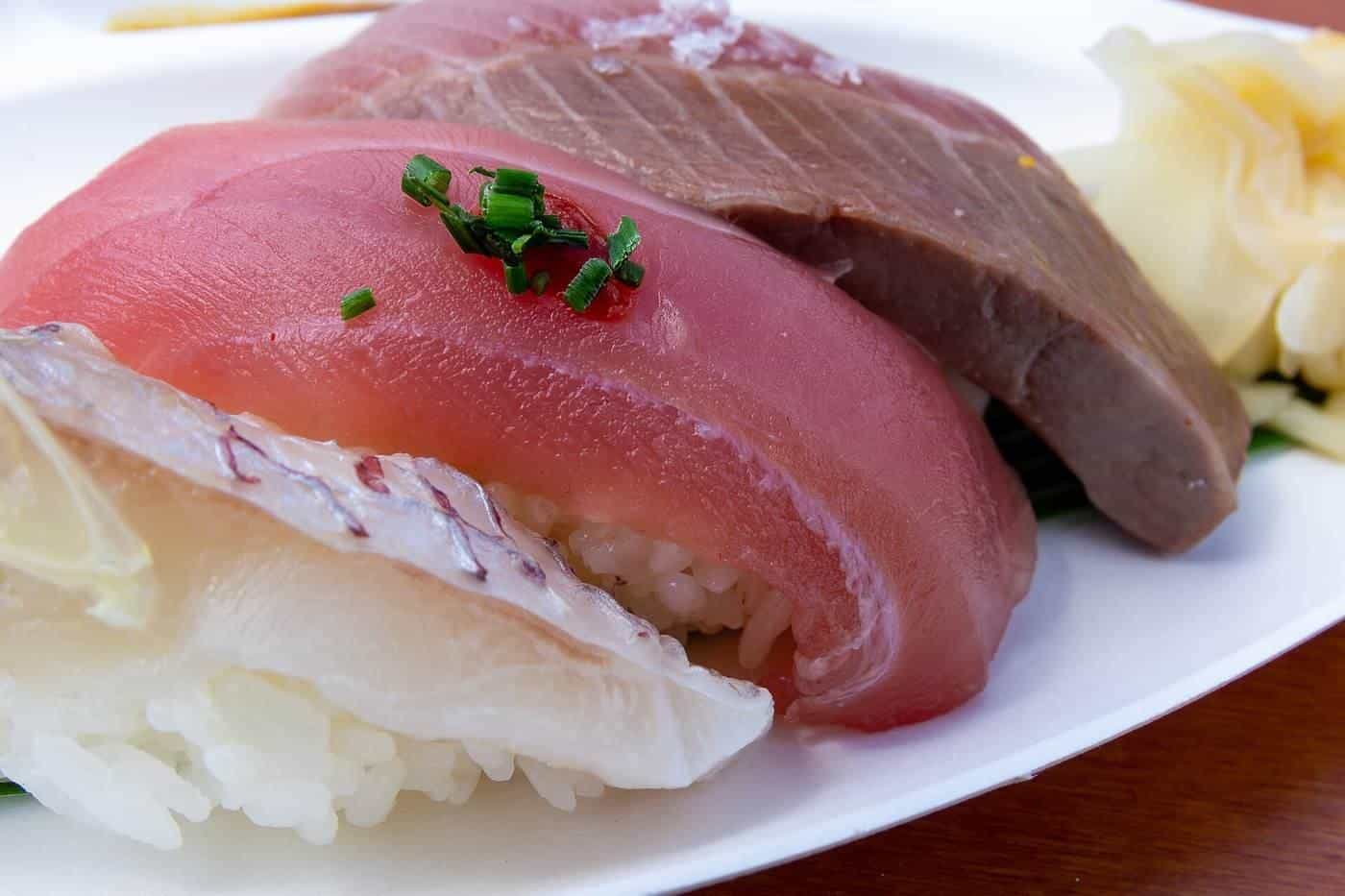 A plate of assorted nigiri sushi with tuna, salmon and white fish