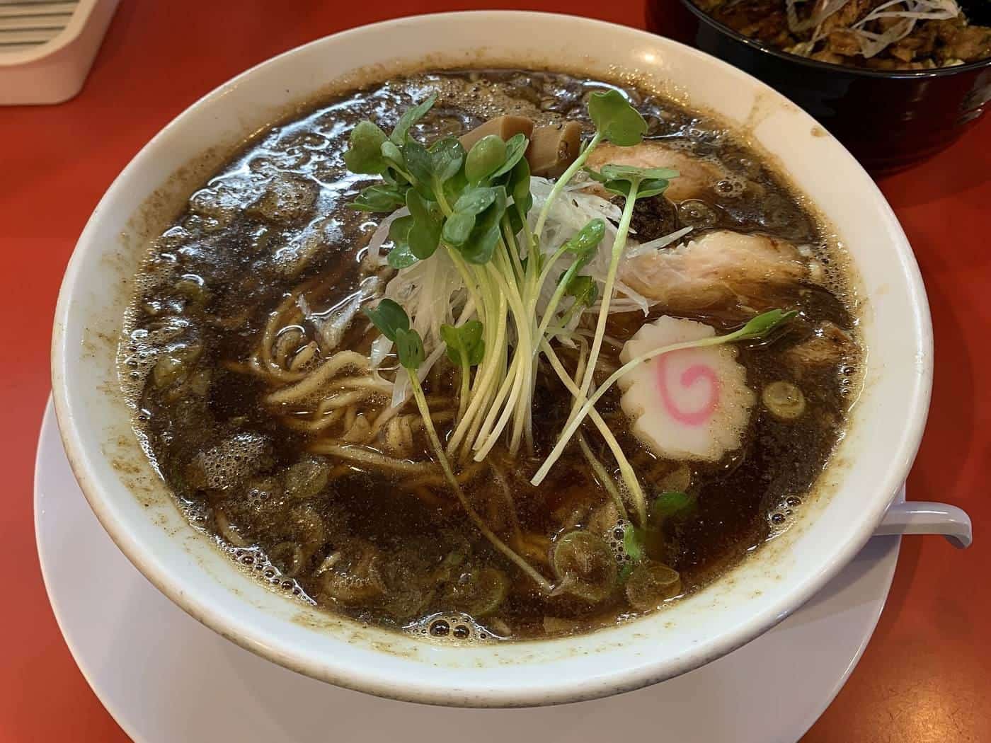 Diners eating and drinking at a busy izakaya table